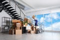 Man with box going up stairs near packed stuff in office Royalty Free Stock Photo