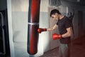Man boxing strikes punching bag, angry, tense.