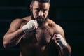 Man boxing workout on ring. Caucasian male boxer in black gloves