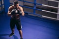 Man boxing workout on ring. Caucasian male boxer in black gloves