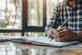 Man brainstorming ideas with a notepad and pen. Hand with pen writing on notebook. Generative AI Royalty Free Stock Photo