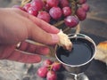 Man breaking the bread, with wine, grapes and Bible in the background Royalty Free Stock Photo