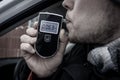 a man with a breathalyzer in the car Royalty Free Stock Photo