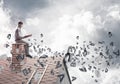 Man on brick roof reading book and symbols flying around