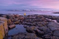 Man In Bright Yellow Raincoat Stands On The Rocky Shore Of  Arctic Ocean.Pink Sunrise On Barents Sea. Landscape With Lone Dreamer Royalty Free Stock Photo