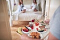 Young man bringing breakfast in bed for two female. lesbian, bisexual, threesome concept