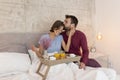 Man bringing a surprise breakfast in bed to woman Royalty Free Stock Photo