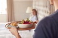 Man Bringing Woman Breakfast In Bed To Celebrate Wedding Anniversary Royalty Free Stock Photo