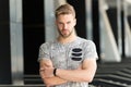 Man bristle serious face muscular shoulders, urban background, defocused. Man beard unshaven guy looks handsome and cool Royalty Free Stock Photo