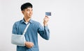 A confident man copes with a broken arm, using credit card Royalty Free Stock Photo