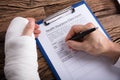 Man With Broken Arm Filling Health Insurance Claim Form Royalty Free Stock Photo