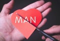 Man.Broken heart. Scissors cut a paper heart with an inscription. A break up. Royalty Free Stock Photo