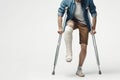 A man with a broken leg in a cast on crutches on a white background. ai generative