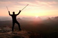 Man with broken leg and medicine pole above head stay on peak.