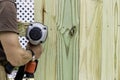 Handyman installs a fence with a pneumatic gun Royalty Free Stock Photo