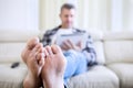 Man browsing the internet focus on bare feet Royalty Free Stock Photo