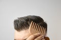 Man brushing his hair with a wooden comb and show how to take care about hair at home. Modern and stylish haircut after Royalty Free Stock Photo