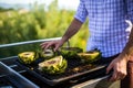 man brushing olive oil on artichokes on a grill