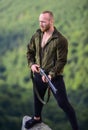 Man brutal poacher with weapon natural landscape background. Hunter poacher looking for victim. Hunter with rifle nature