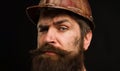 Man builder. Closeup portrait serious construction worker in building hard hat. Bearded workman in protective helmet Royalty Free Stock Photo