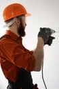 Man builder in hardhat drilling wall with drill perforator Royalty Free Stock Photo