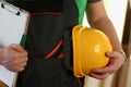 Man builder holding documents and safety helmet in his hands closeup Royalty Free Stock Photo