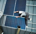 Man technician mounting photovoltaic solar panels on roof of house with help of hex key. Royalty Free Stock Photo