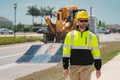 Man builder near excavator. Builder worker with excavator. Builder in helmet. Worker in hardhat. Portrait mechanical