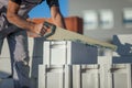 Man builder sawing a gas-silicate block