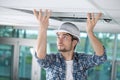 Man in builder uniform hand up installing suspended ceiling Royalty Free Stock Photo