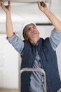 man in builder uniform installing suspended ceiling