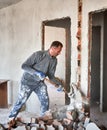 Male worker breaking wall with sledgehammer in apartment. Royalty Free Stock Photo