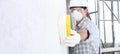 Man builder using a sponge on  wall professional construction worker with mask, safety hard hat, gloves and protective glasses. Royalty Free Stock Photo