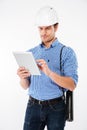 Man building engineer in hard hat standing and using tablet