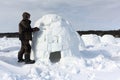 Man building an igloo from snow blocks in the winter, Novosibirsk, Russia