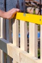 Man building a wooden fence and checking with spirit level. Close up of his hand and the tool in a DIY concept. Royalty Free Stock Photo