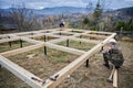 Man worker building wooden frame house on pile foundation. Royalty Free Stock Photo