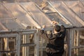 A man builds a greenhouse in the country