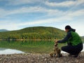 Man built pyramid from pebbles. Balanced stone pyramide on shore of blue water of mountain lake. Royalty Free Stock Photo