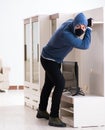 Man burglar stealing tv set from house Royalty Free Stock Photo