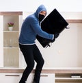 Man burglar stealing tv set from house Royalty Free Stock Photo