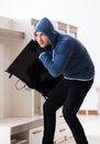 Man burglar stealing tv set from house Royalty Free Stock Photo