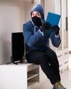 Man burglar stealing tv set from house Royalty Free Stock Photo