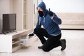 The man burglar stealing tv set from house