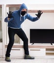 Man burglar stealing tv set from house Royalty Free Stock Photo