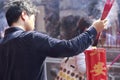 Man burn incense on large red candle