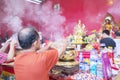 Man burning incensed paper in temple