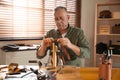 Man burnishing edges of leather belt Royalty Free Stock Photo