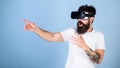 Man with bushy beard in VR glasses using digital touch screen interface. Macho with hipster beard frightened of