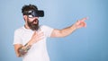 Man with bushy beard in VR glasses using digital touch screen interface. Macho with hipster beard frightened of